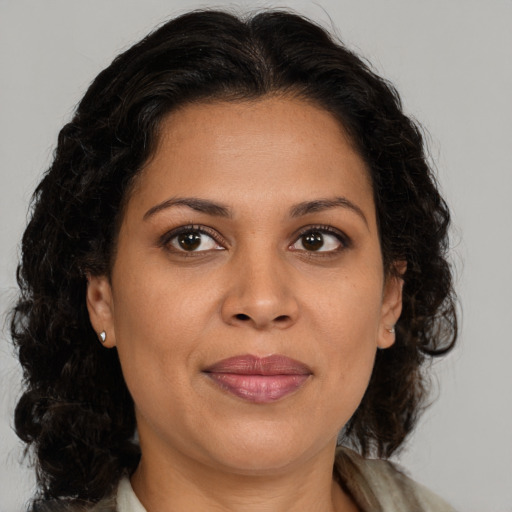 Joyful latino adult female with medium  brown hair and brown eyes
