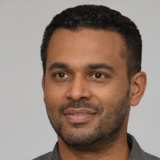 Joyful latino adult male with short  black hair and brown eyes