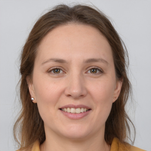 Joyful white young-adult female with long  brown hair and grey eyes