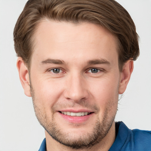 Joyful white young-adult male with short  brown hair and grey eyes