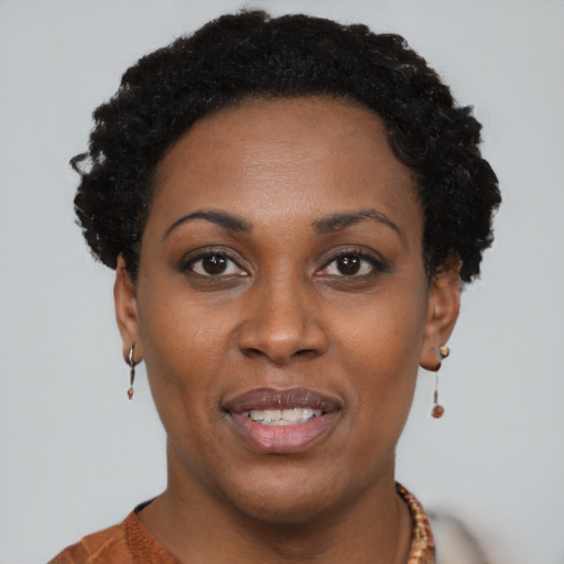 Joyful black young-adult female with short  black hair and brown eyes