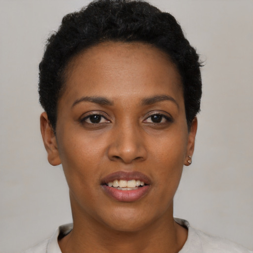 Joyful black young-adult female with short  black hair and brown eyes