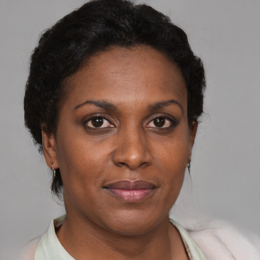 Joyful black adult female with short  brown hair and brown eyes