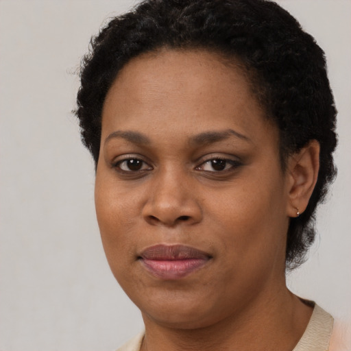 Joyful black young-adult female with short  black hair and brown eyes