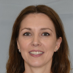 Joyful white adult female with long  brown hair and brown eyes