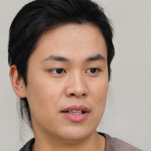 Joyful asian young-adult male with medium  brown hair and brown eyes