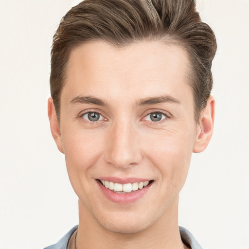 Joyful white young-adult male with short  brown hair and grey eyes