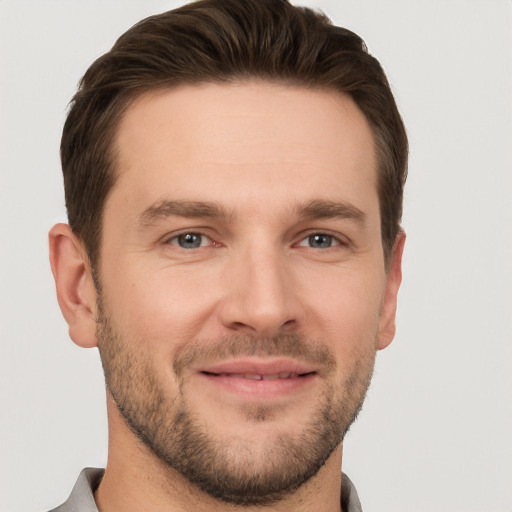 Joyful white young-adult male with short  brown hair and grey eyes