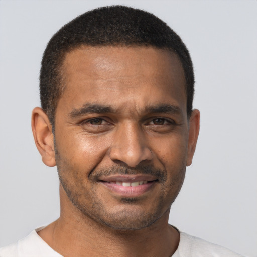 Joyful black young-adult male with short  brown hair and brown eyes