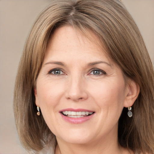 Joyful white adult female with medium  brown hair and grey eyes