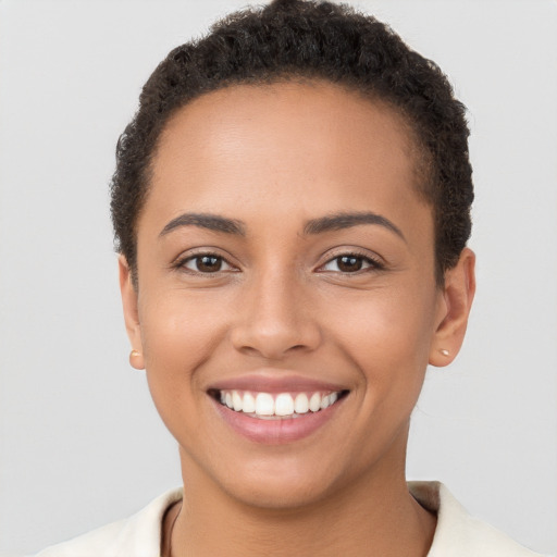 Joyful latino young-adult female with short  brown hair and brown eyes