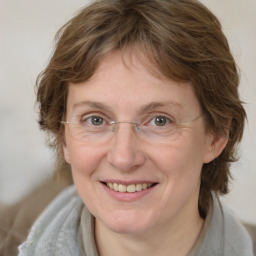 Joyful white adult female with medium  brown hair and blue eyes