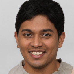 Joyful latino young-adult male with short  brown hair and brown eyes