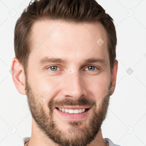 Joyful white young-adult male with short  brown hair and grey eyes