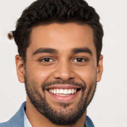 Joyful white young-adult male with short  black hair and brown eyes