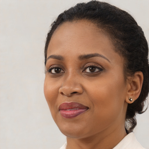 Joyful black adult female with medium  brown hair and brown eyes