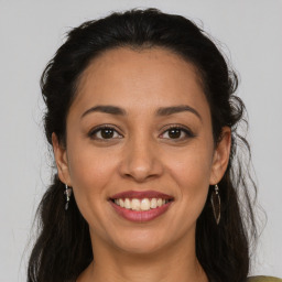 Joyful latino young-adult female with medium  brown hair and brown eyes