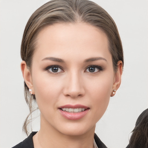 Joyful white young-adult female with medium  brown hair and grey eyes