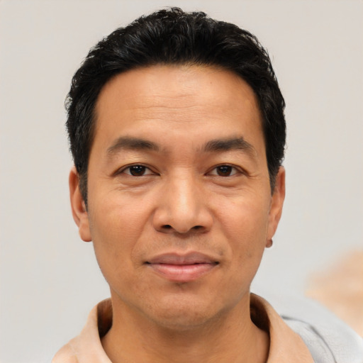 Joyful asian adult male with short  black hair and brown eyes