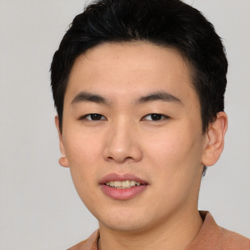 Joyful asian young-adult male with short  black hair and brown eyes