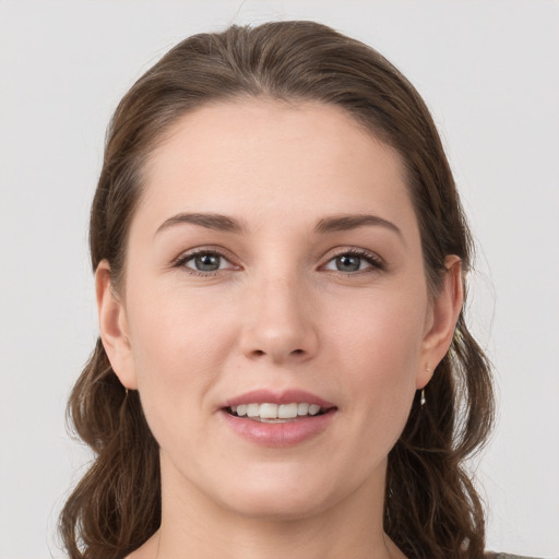 Joyful white young-adult female with medium  brown hair and grey eyes