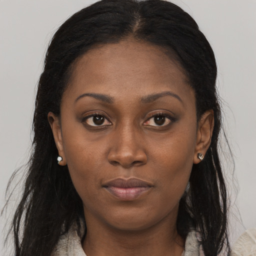 Joyful black young-adult female with long  brown hair and brown eyes