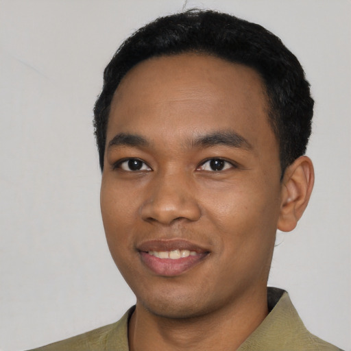 Joyful black young-adult male with short  black hair and brown eyes