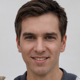 Joyful white adult male with short  brown hair and grey eyes