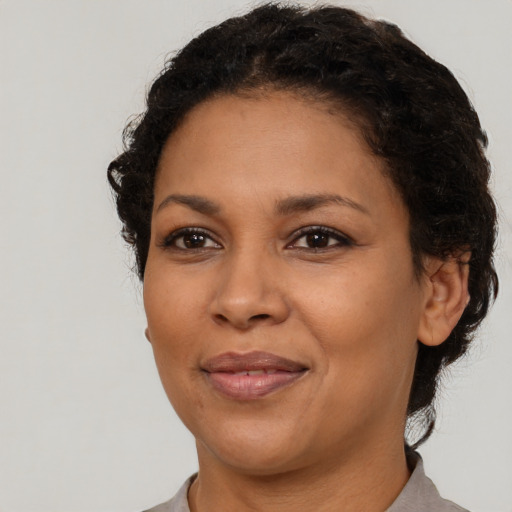 Joyful black adult female with short  brown hair and brown eyes