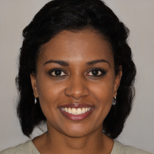 Joyful black young-adult female with medium  black hair and brown eyes