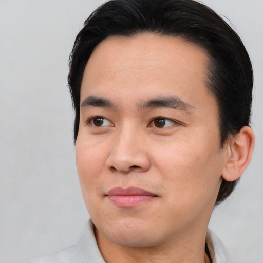 Joyful asian young-adult male with short  brown hair and brown eyes