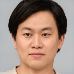 Joyful asian young-adult male with short  brown hair and brown eyes