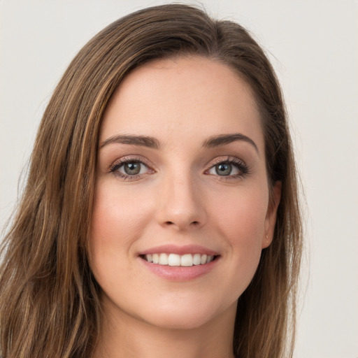 Joyful white young-adult female with long  brown hair and green eyes