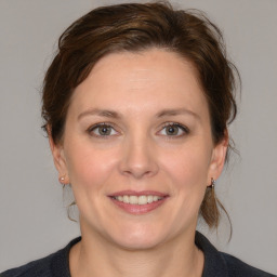 Joyful white young-adult female with medium  brown hair and blue eyes