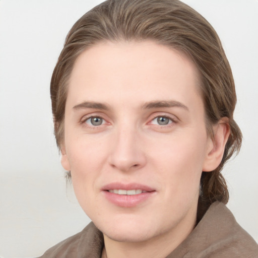 Joyful white young-adult female with medium  brown hair and grey eyes