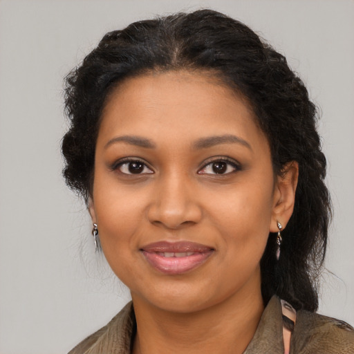Joyful black young-adult female with long  brown hair and brown eyes