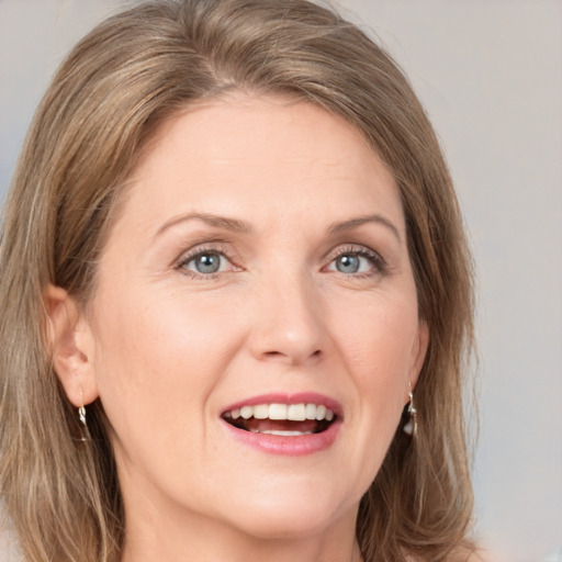 Joyful white adult female with medium  brown hair and grey eyes