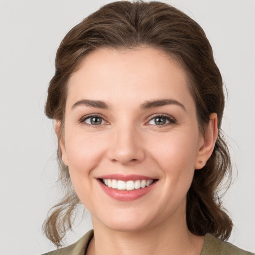 Joyful white young-adult female with medium  brown hair and grey eyes