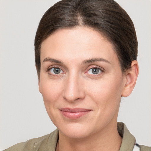 Joyful white young-adult female with medium  brown hair and grey eyes