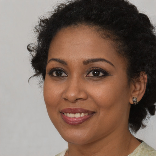 Joyful black young-adult female with short  brown hair and brown eyes