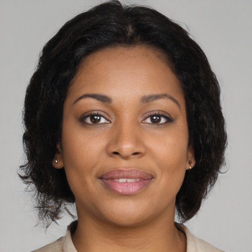 Joyful black young-adult female with medium  brown hair and brown eyes