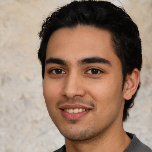 Joyful white young-adult male with short  black hair and brown eyes