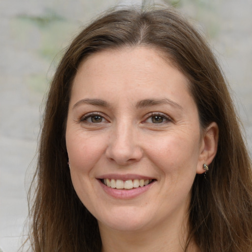 Joyful white adult female with long  brown hair and brown eyes