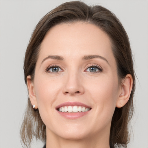 Joyful white young-adult female with medium  brown hair and grey eyes