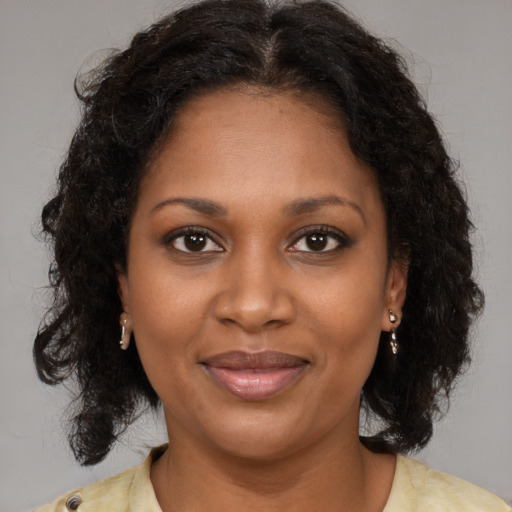 Joyful black young-adult female with medium  brown hair and brown eyes