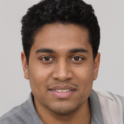 Joyful latino young-adult male with short  black hair and brown eyes