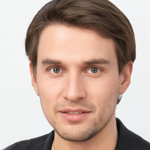 Joyful white young-adult male with short  brown hair and grey eyes