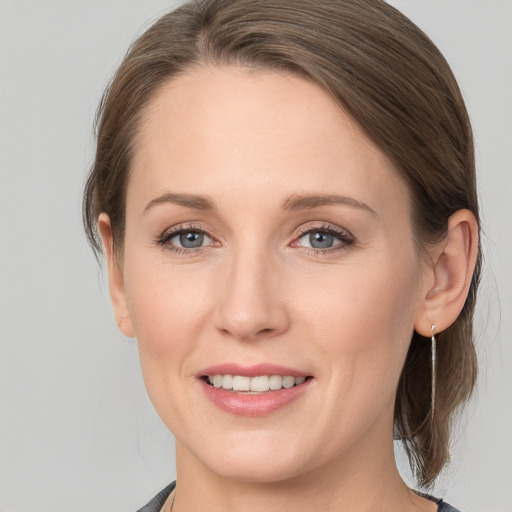 Joyful white young-adult female with medium  brown hair and grey eyes