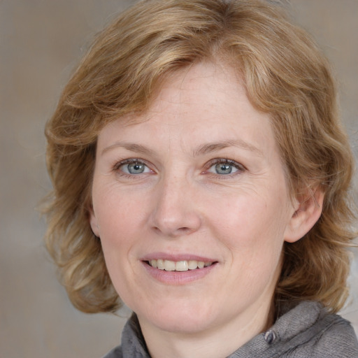 Joyful white adult female with medium  brown hair and blue eyes