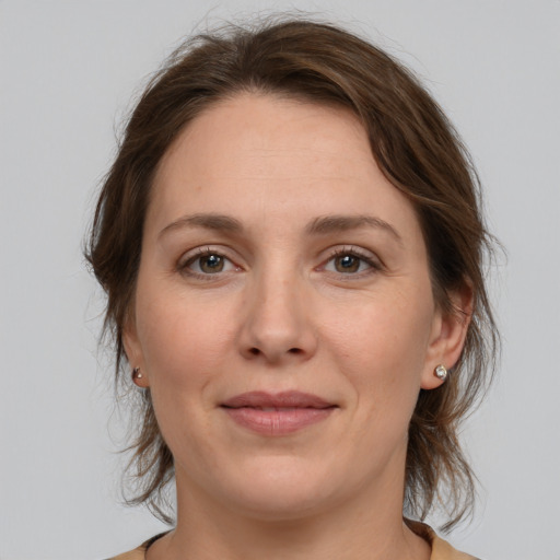 Joyful white adult female with medium  brown hair and grey eyes